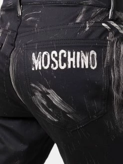 Moschino faded logo-print trousers